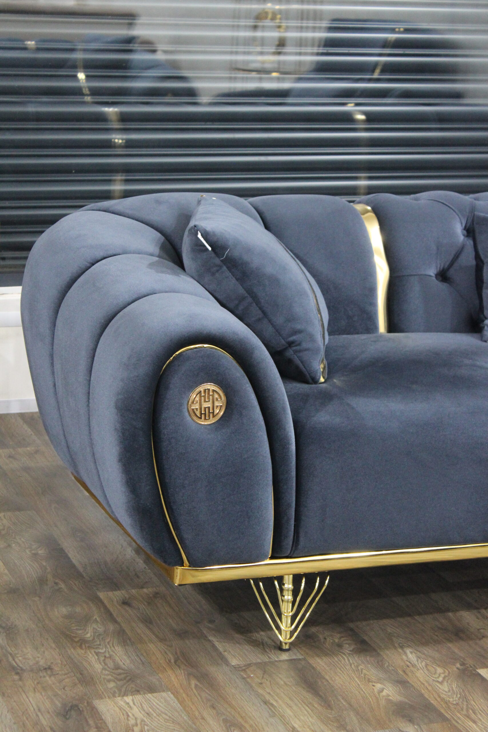 Midnight blue velvet sofa set with gold trim and accent chair in luxury living room setup