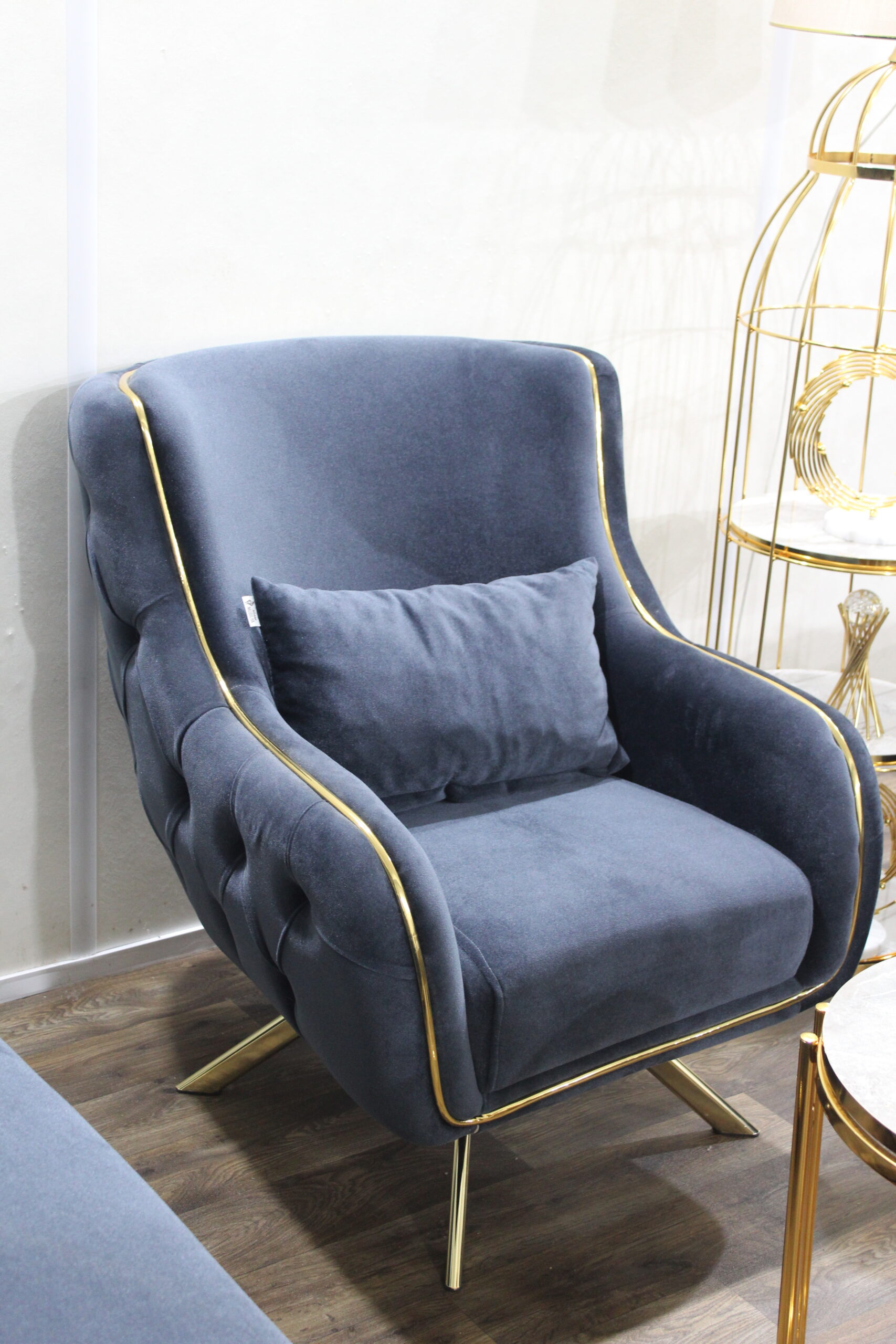 Midnight blue velvet sofa set with gold trim and accent chair in luxury living room setup